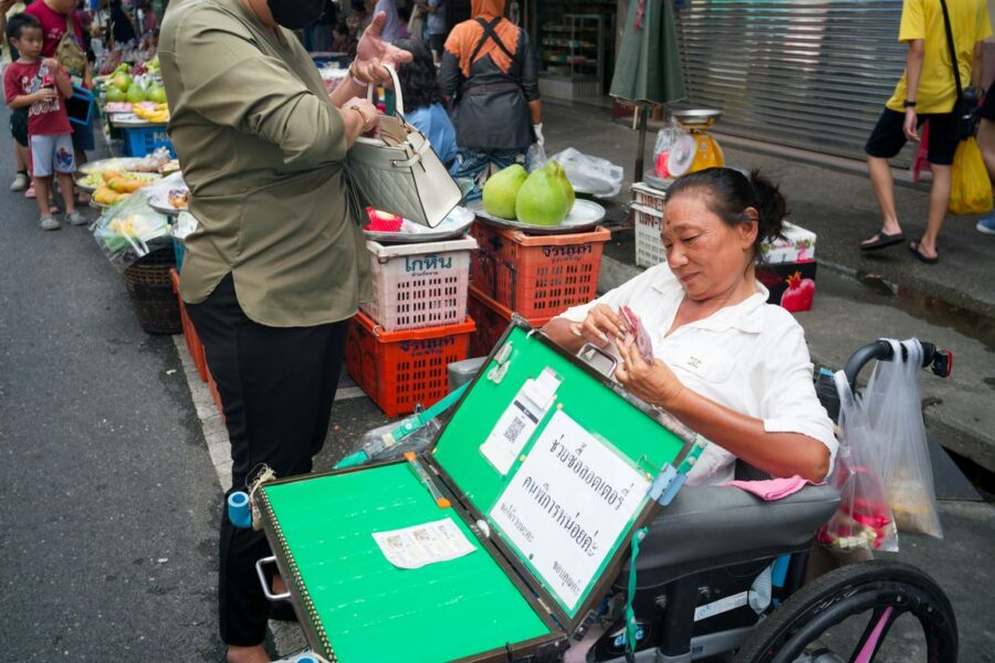 Woman in wheelchair selling items at market