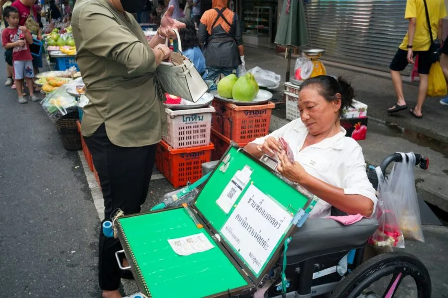 Woman in wheelchair selling items at market