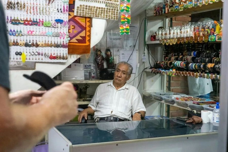 man in white dress shirt standing in front of counter