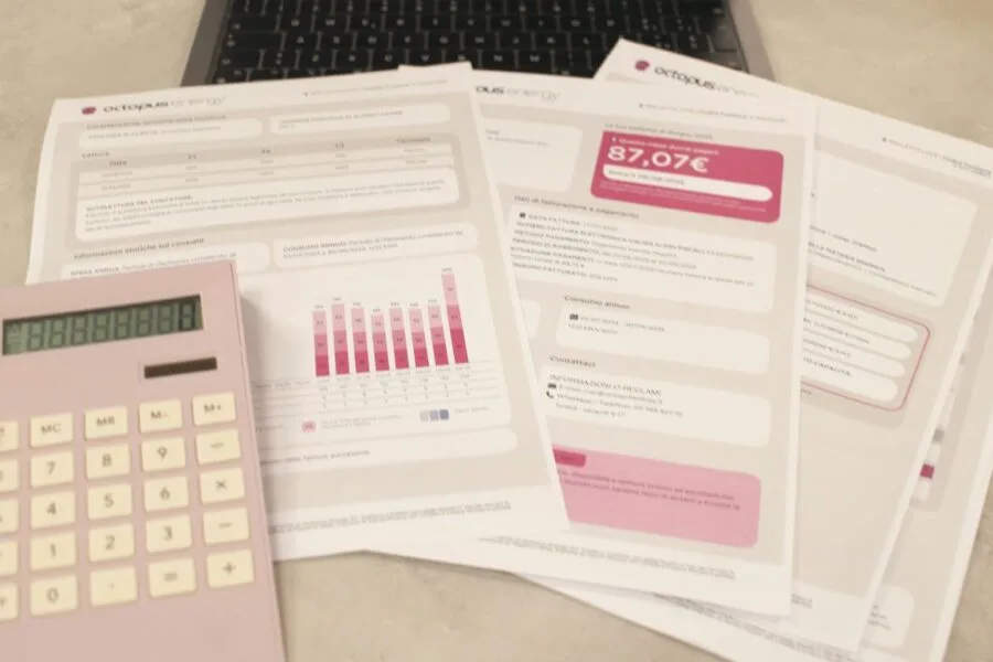 Bills, calculator, and a laptop: financial tasks underway.