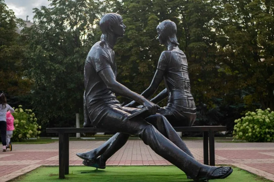 a statue of a man and a woman sitting on a bench